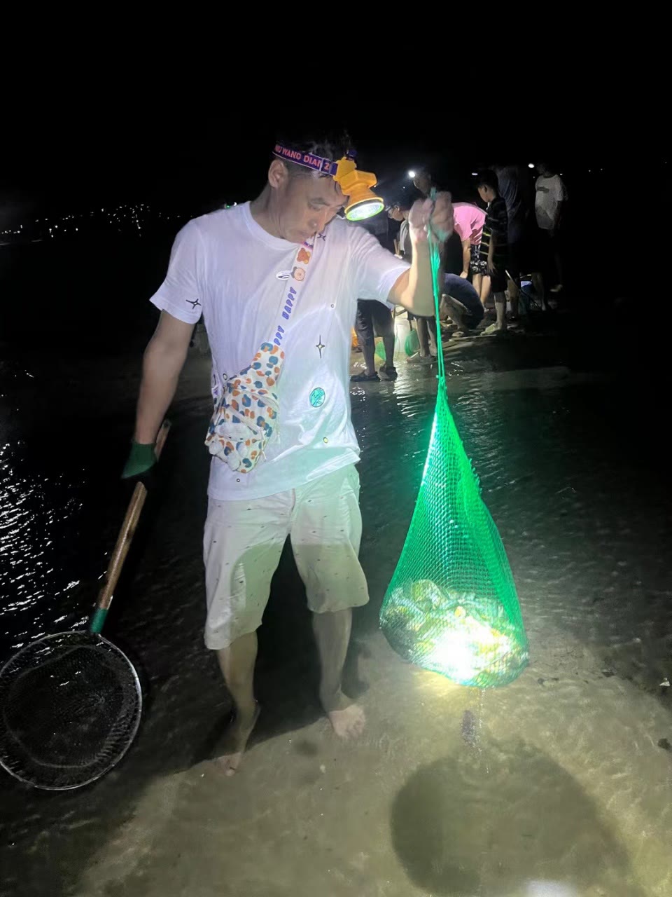 游客夜间使用网兜赶海